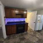 Kitchen with under-cabinet LED lighting, glass-top range, fridge, that door there goes to the bathroom